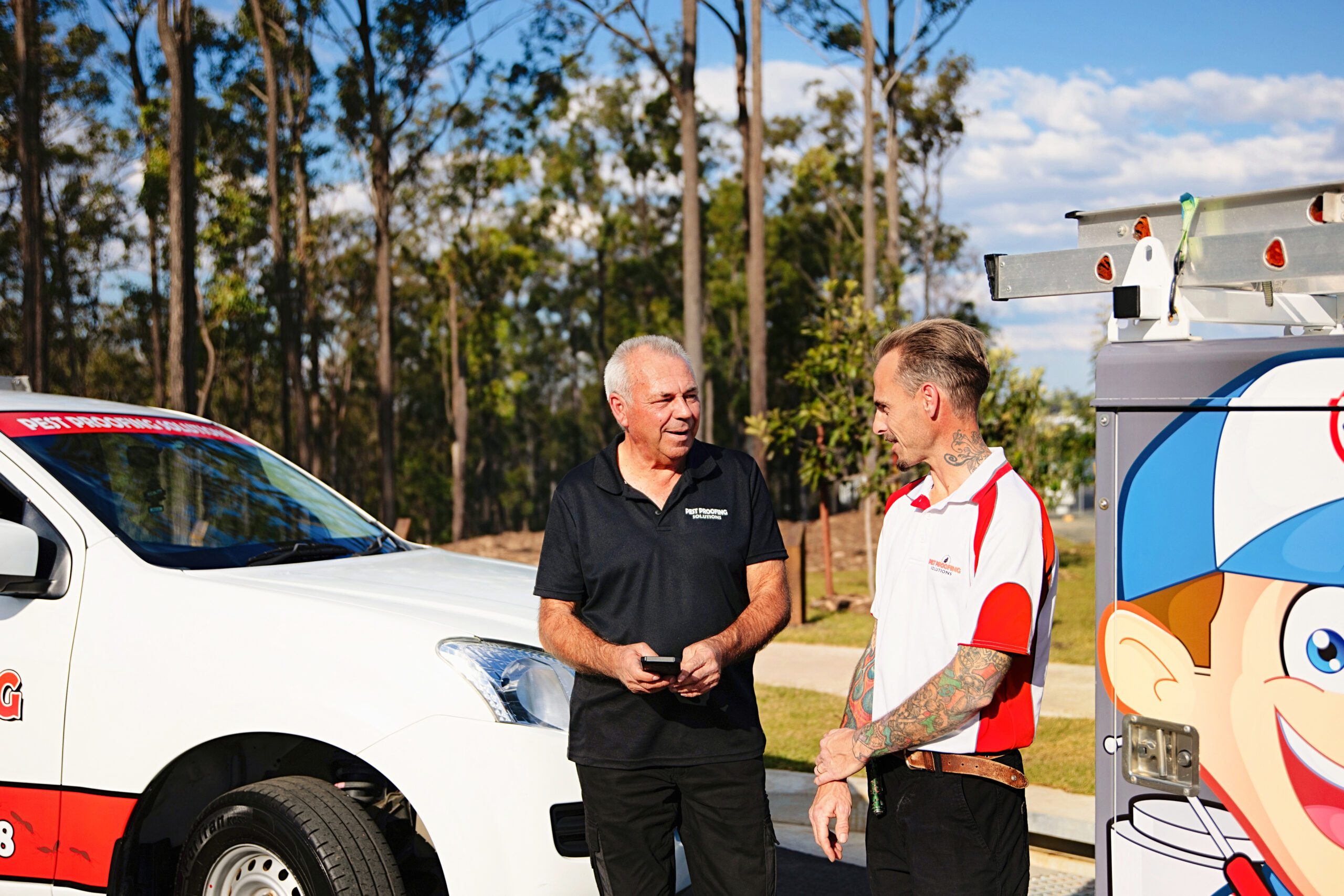 Two professional pest control experts talking outside | Feature Image for the Brisbane Possum Removal page for Pest Proofing Solutions.